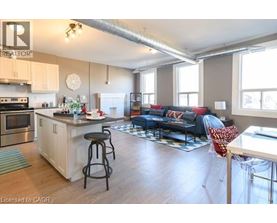A spacious open plan living and kitchen area with a bar stool.