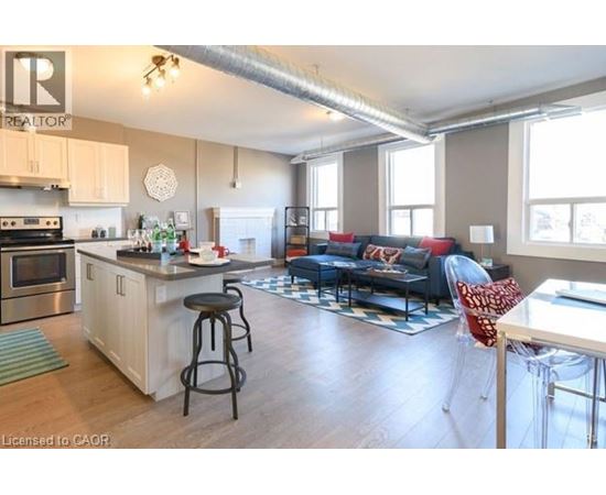 A spacious open plan living and kitchen area with a bar stool.