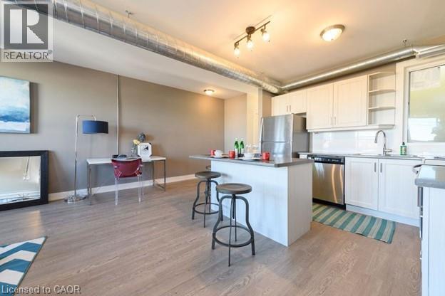 A kitchen with white cabinets and a wooden floor.