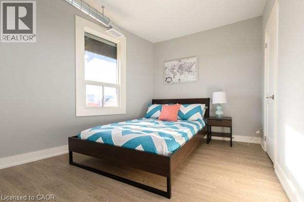 A bedroom with a bed, nightstand, and window.