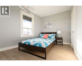 A bedroom with a bed, nightstand, and window.