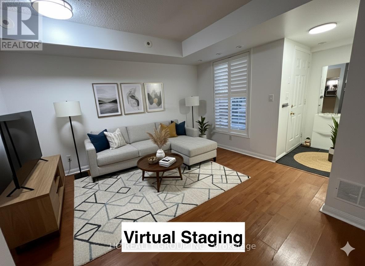 A living room with a couch, coffee table, and a television.