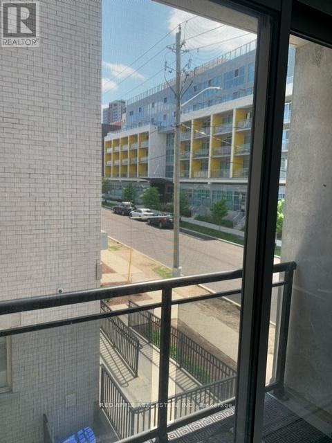 A view from a window looking out at a street with cars and buildings.