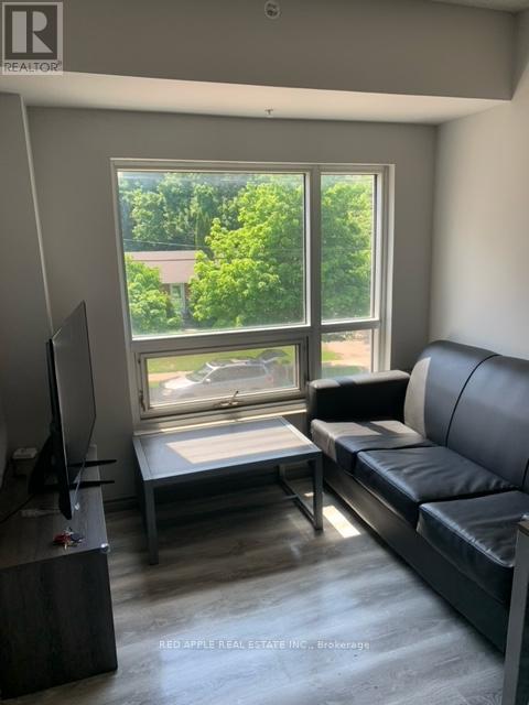 A living room with a couch, a television, and a window.