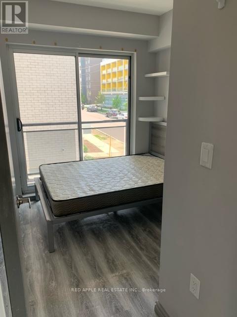 A bedroom with a bed, shelves, and a sliding glass door.