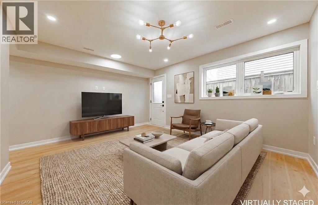A living room with a couch, a television, and a chandelier.