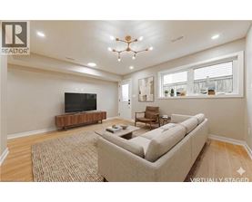 A living room with a couch, a television, and a chandelier.