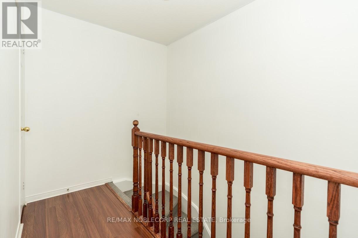 A white door is open to reveal a white washer and dryer in a small space.