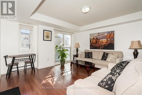 A living room with a couch, coffee table, and a painting on the wall.