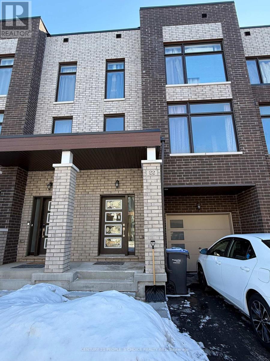 A white car is parked in front of a brown building with a garage.