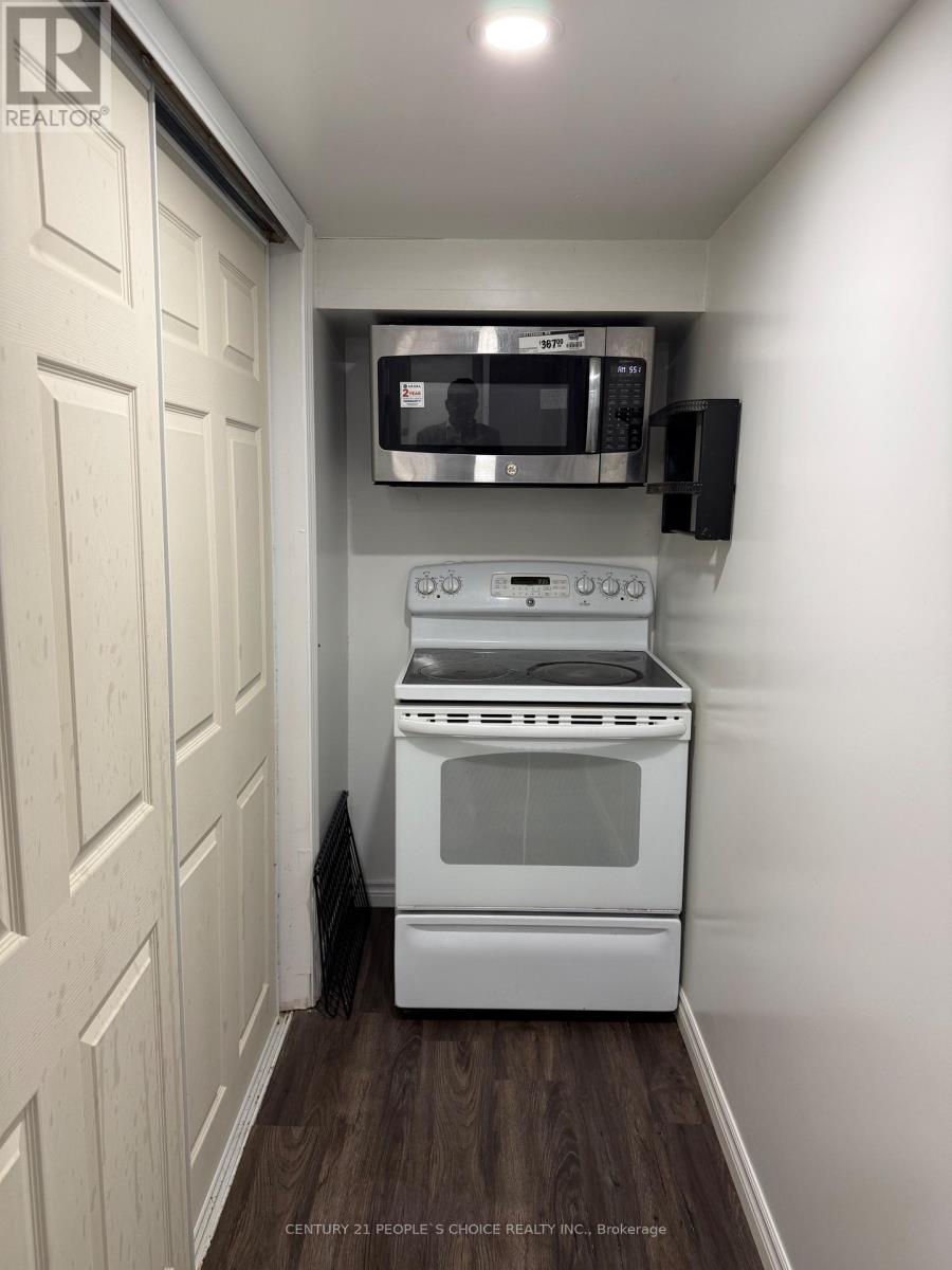 A small kitchen with a white oven and microwave above it.
