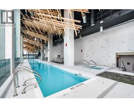 A large indoor swimming pool with a wooden structure above it.