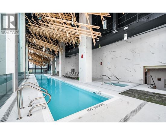 A large indoor swimming pool with a wooden structure above it.