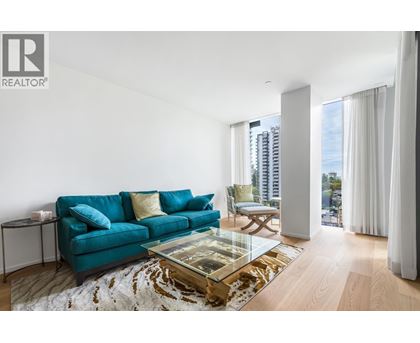 A living room with a blue couch and a glass coffee table.