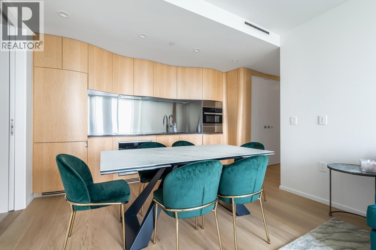 A modern kitchen with a dining table and chairs.