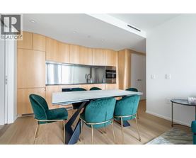 A modern kitchen with a dining table and chairs.