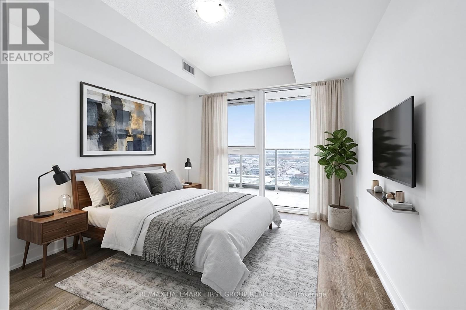 A bedroom with a large bed and a flat screen TV mounted on the wall.