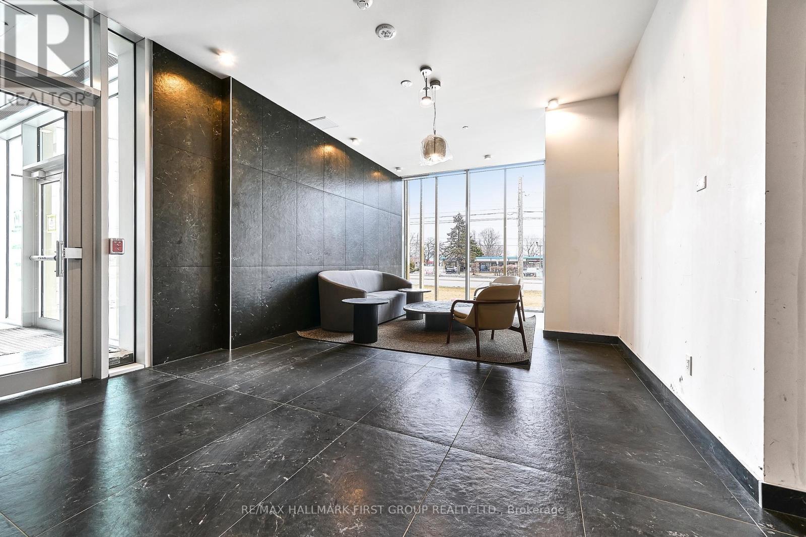 A spacious room with a black floor and a large window.