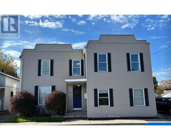 A two-story house with a blue door and windows.