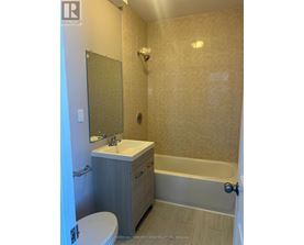 A bathroom with a toilet, sink, and bathtub.