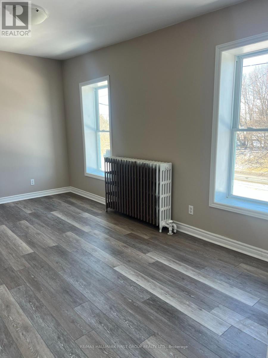 A room with a grey floor and a window with a white frame.