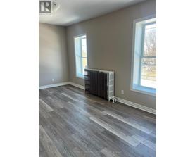 A room with a grey floor and a window with a white frame.
