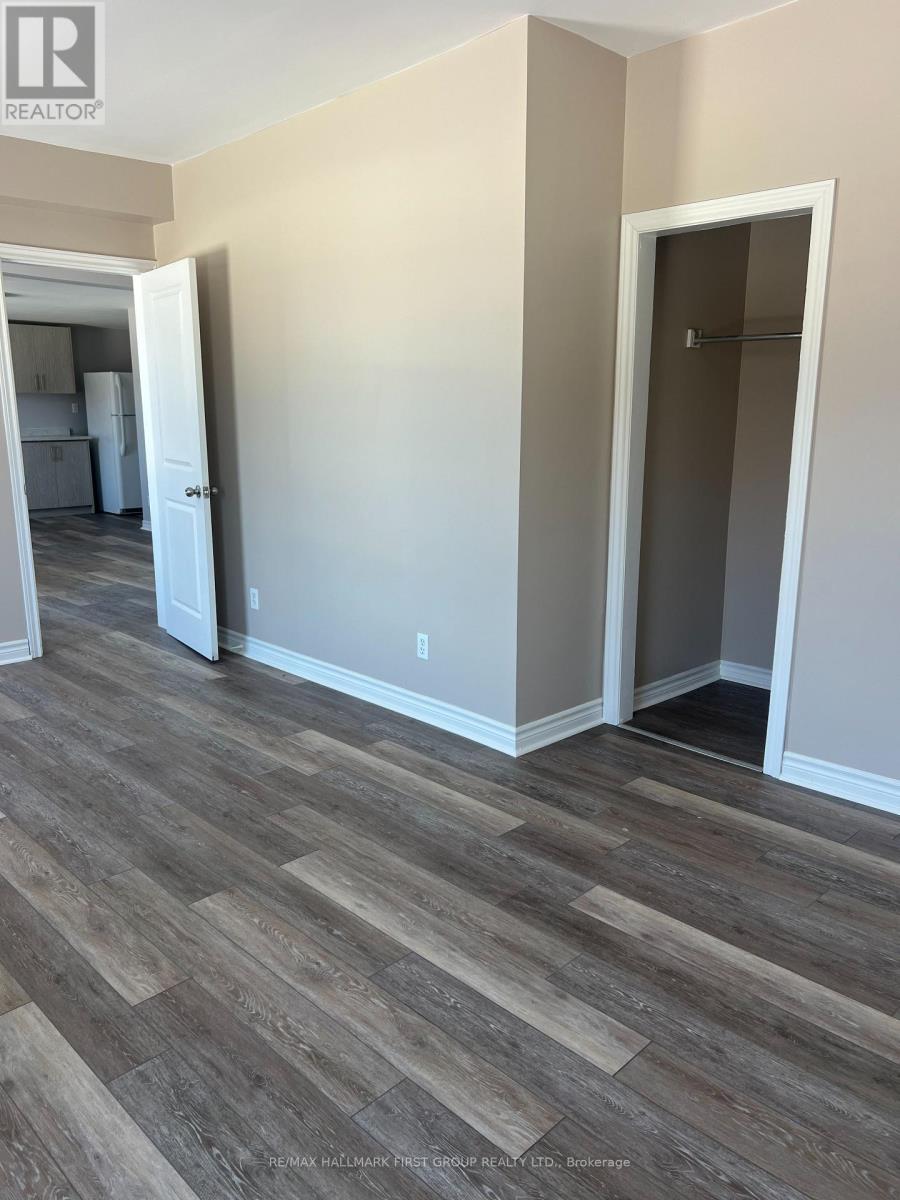 A room with wood flooring and a doorway leading to another room.