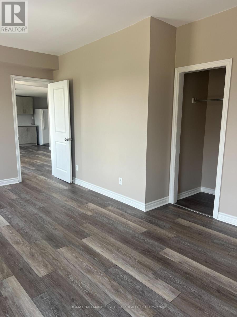 A room with a wooden floor and a doorway leading to another room.