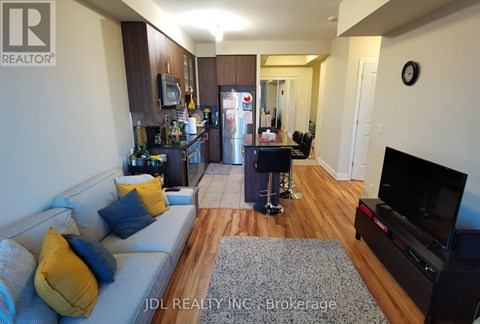 A living room with a grey couch and a wooden floor.
