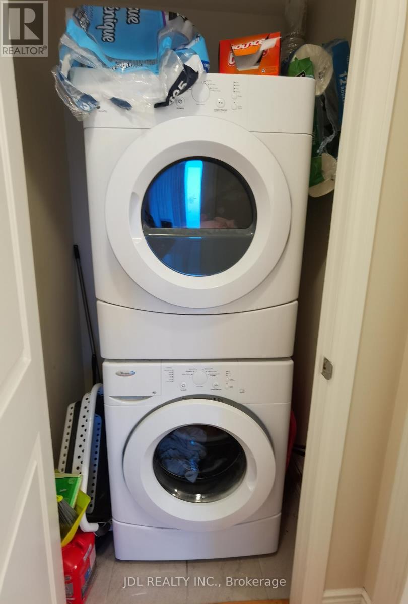 A stack of two white washing machines in a small space.