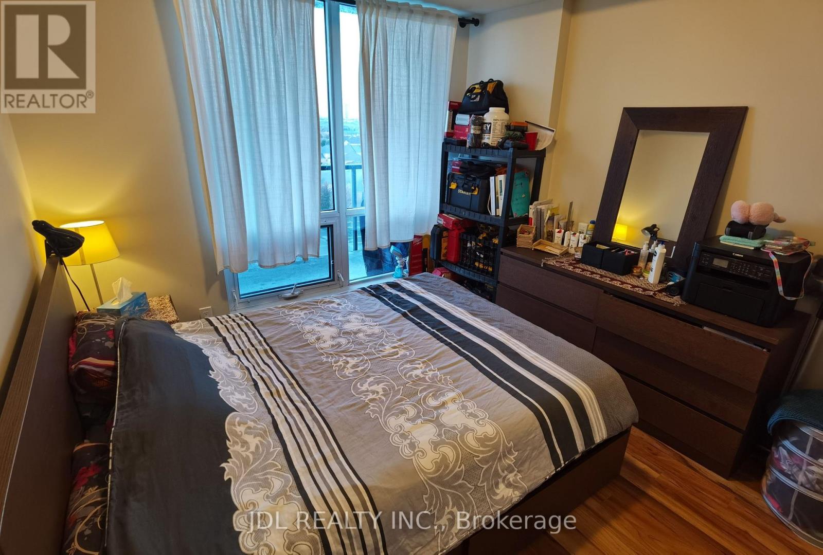 A bedroom with a bed, dresser, and mirror.