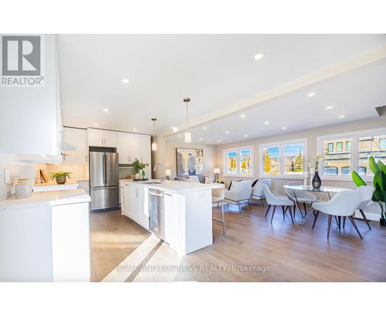 A modern kitchen with white cabinets and a large island.