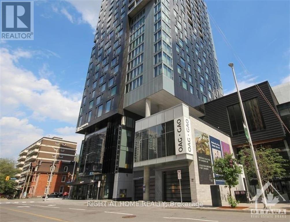 A tall building with a glass facade stands in front of a smaller building with a brown facade.