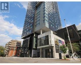 A tall building with a glass facade stands in front of a smaller building with a brown facade.