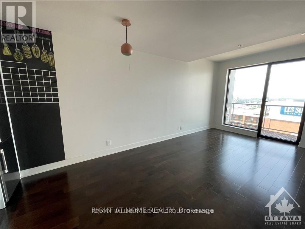 A room with a blackboard and a window overlooking a balcony.