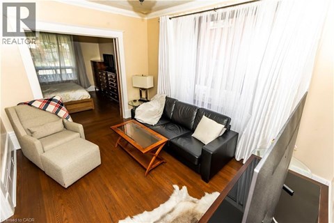 A living room with a black couch and a wooden coffee table.