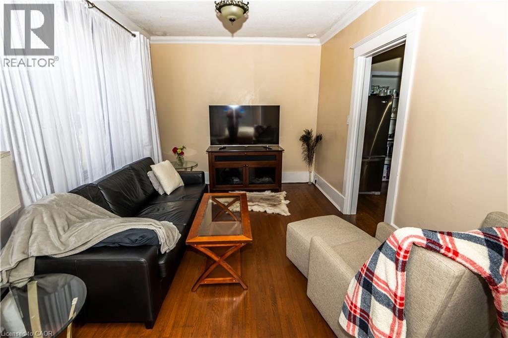 A living room with a black couch, a wooden coffee table, and a television.