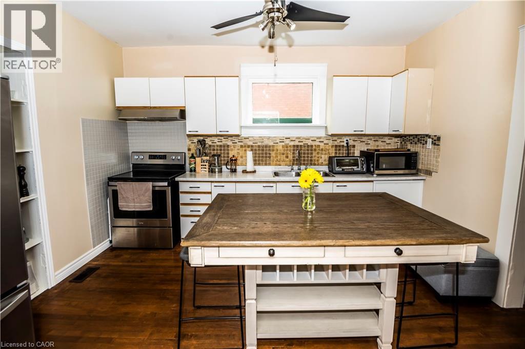 A kitchen with a wooden table and a fan on the ceiling.
