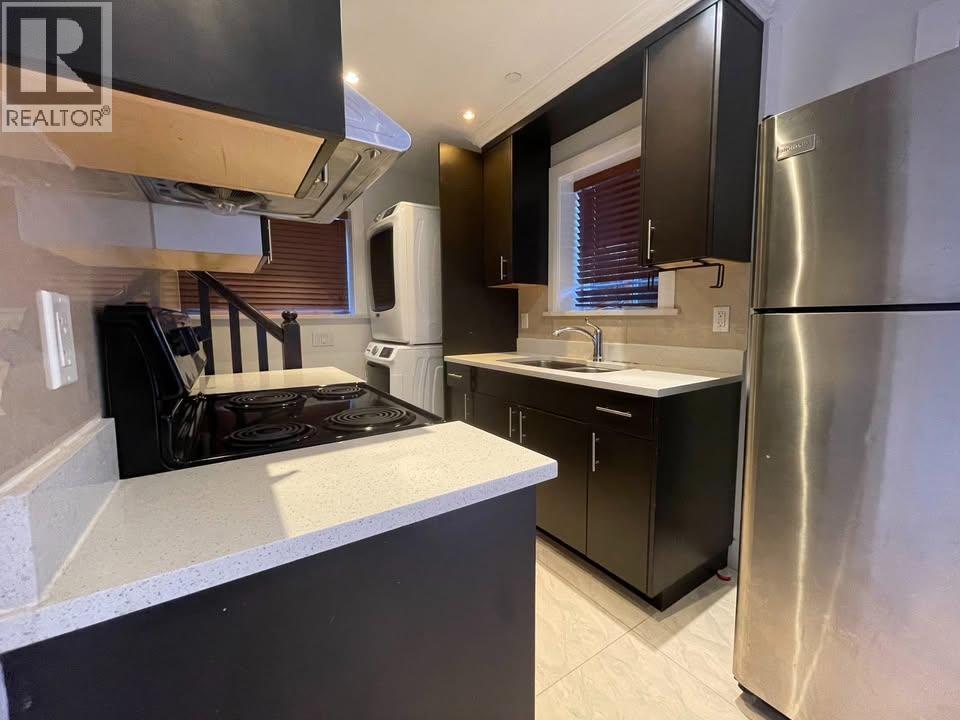 A modern kitchen with a stove top oven and a refrigerator.