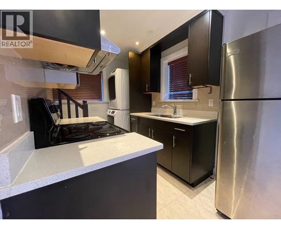 A modern kitchen with a stove top oven and a refrigerator.