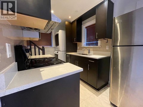 A modern kitchen with a stove top oven and a refrigerator.