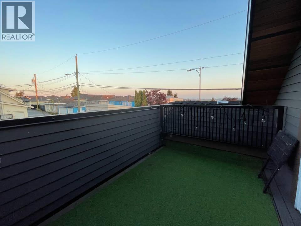 A balcony with a black railing and a green carpet.