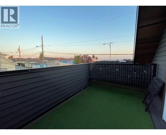 A balcony with a black railing and a green carpet.