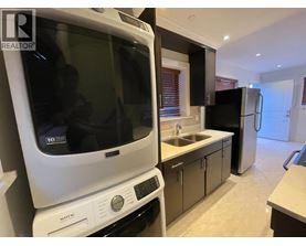 A white Maytag dishwasher is in a kitchen with black appliances.