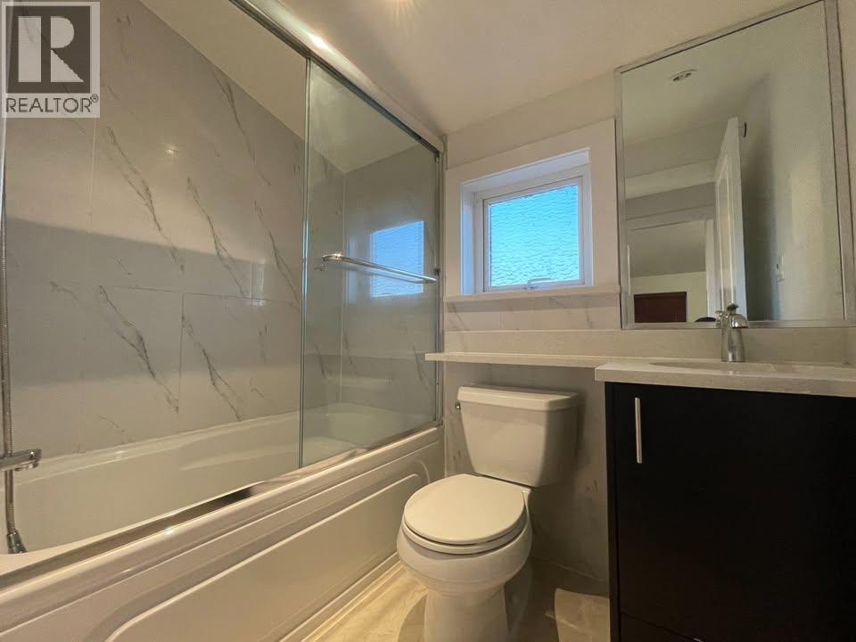 A bathroom with a toilet, sink, and bathtub.