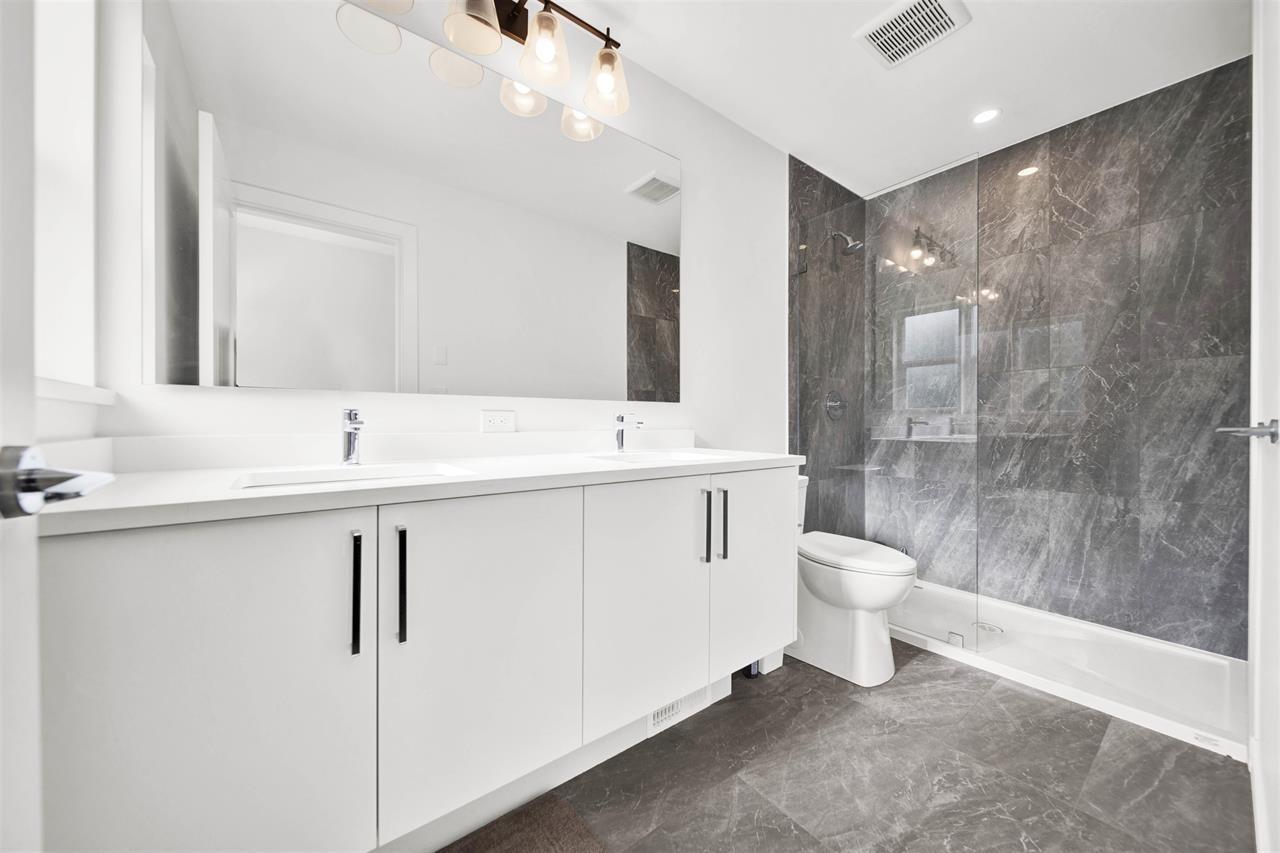 A bathroom with a marble wall and a white toilet.