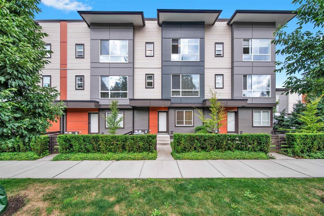 A modern apartment building with a mix of grey and orange colors.