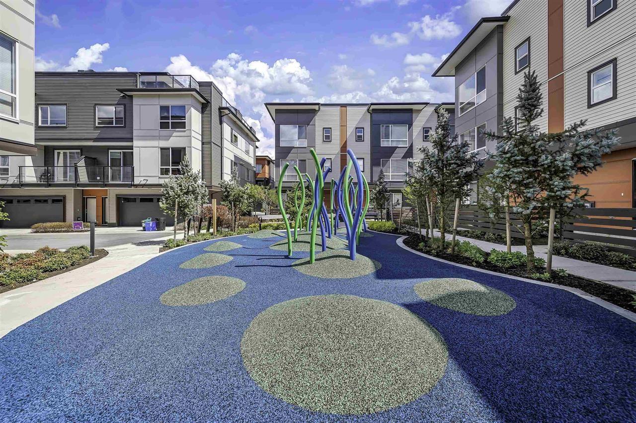 A playground with a blue surface and a green and blue play structure.