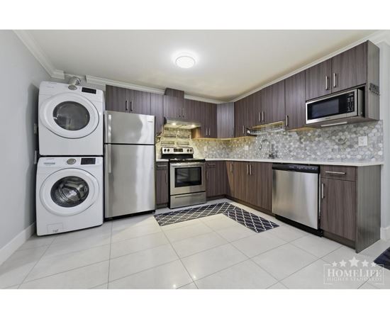 A kitchen with a washer and dryer built into the cabinetry.