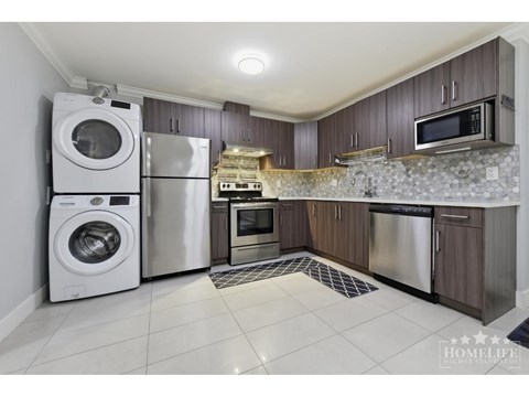 A kitchen with a washer and dryer built into the cabinetry.